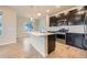 Modern kitchen with dark wood cabinets, stainless steel appliances, and a large center island at 5107 S Fairplay St, Aurora, CO 80015