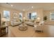 Bright living room featuring neutral tones, two sofas, an armchair, and abundant natural light from large windows at 5107 S Fairplay St, Aurora, CO 80015