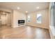 Sunlit living room with wood floors, a modern fireplace, and ample natural light from large windows at 5107 S Fairplay St, Aurora, CO 80015