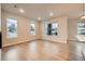 Open-concept living area with hardwood floors, recessed lighting, and large windows providing natural light at 5107 S Fairplay St, Aurora, CO 80015