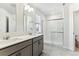 Clean and modern bathroom with double vanity, walk-in shower with glass door and tile flooring at 4635 Cattle Cross Trl, Castle Rock, CO 80104