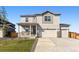 Inviting two-story home with a covered front porch, three car garage and manicured lawn at 4635 Cattle Cross Trl, Castle Rock, CO 80104