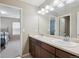 Bathroom featuring double sinks and dark wood vanity, adjacent to bedroom at 2810 Shadow Dance Dr, Castle Rock, CO 80109