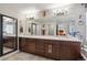 Bathroom featuring double sink vanity with dark wood cabinets and a large mirror at 2810 Shadow Dance Dr, Castle Rock, CO 80109