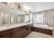 Bathroom featuring a double vanity sink, bathtub, and a separate glass-enclosed shower at 2810 Shadow Dance Dr, Castle Rock, CO 80109