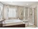 Bright bathroom featuring a soaking tub and tiled glass enclosed shower at 2810 Shadow Dance Dr, Castle Rock, CO 80109