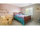 Charming bedroom with light pink walls, wooden furniture, and natural light at 2810 Shadow Dance Dr, Castle Rock, CO 80109