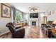 Bright living room with a fireplace, hardwood floors, and large windows bringing in natural light at 2810 Shadow Dance Dr, Castle Rock, CO 80109