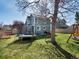 Large backyard with a trampoline, green grass, mature trees, and a bench; perfect for Gathering fun and relaxation at 5557 S Simms Way, Littleton, CO 80127