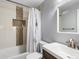 Bathroom featuring a bathtub with a shower, a tiled niche, and a modern vanity at 5557 S Simms Way, Littleton, CO 80127