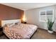 Comfortable bedroom featuring a warm accent wall and natural light from the window at 5557 S Simms Way, Littleton, CO 80127