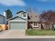 Charming two-story home featuring a two-car garage, brick accents, and a well-maintained lawn on a sunny day at 5557 S Simms Way, Littleton, CO 80127