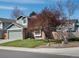 Two-story home with a two-car garage, brick accents, and mature trees on a corner lot with blue skies at 5557 S Simms Way, Littleton, CO 80127
