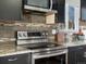 Close up of a kitchen showcasing stainless steel appliances, modern backsplash, and granite counters at 5557 S Simms Way, Littleton, CO 80127