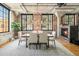 Open dining area features brick accent wall, fireplace, modern chandelier, and lots of natural light at 1863 Wazee St # 4E, Denver, CO 80202