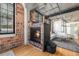 Living room featuring a modern fireplace, hardwood floors, and exposed brick walls at 1863 Wazee St # 4E, Denver, CO 80202