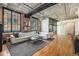 Bright living room with exposed brick, concrete ceiling, hardwood floors, and large windows at 1863 Wazee St # 4E, Denver, CO 80202
