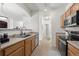 Efficient kitchen featuring wood cabinets, stainless steel appliances, and an open view into the living area at 5255 Memphis St # 811, Denver, CO 80239