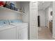 Efficient laundry area with washer, dryer, and overhead shelving for organized storage solutions at 5255 Memphis St # 811, Denver, CO 80239