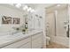 Bathroom with a double sink vanity, mirrors, and a tub-shower combination at 27664 E Byers Ave, Aurora, CO 80018