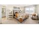 Relaxing bedroom featuring a gray upholstered bed, patterned pillows, and a side chair at 27664 E Byers Ave, Aurora, CO 80018