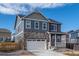 Charming two-story home with a stone facade, white garage door, and red shutters at 27664 E Byers Ave, Aurora, CO 80018