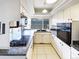 Galley kitchen features white cabinets, tile floors, black appliances, and a window at 630 S Youngfield Ct, Lakewood, CO 80228