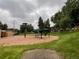 Community playground with multiple play structures on a large sandlot, surrounded by grassy areas at 630 S Youngfield Ct, Lakewood, CO 80228