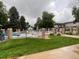 Community pool surrounded by black metal fence, lawn furniture and manicured landscaping at 630 S Youngfield Ct, Lakewood, CO 80228