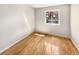 Bright, empty bedroom with hardwood floors, a window overlooking the backyard, and neutral walls at 13784 W 67Th Way, Arvada, CO 80004