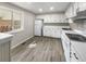 Well-lit kitchen with white cabinets, modern appliances, and laminate flooring at 13784 W 67Th Way, Arvada, CO 80004