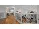 Bright hallway with hardwood floors, wrought iron railing, and an open view to the living room and bedroom at 10383 Erin Pl, Lone Tree, CO 80124