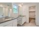 Bathroom featuring dual sinks, gray countertops, white cabinets, and a shower over tub combination at 7357 S Yank Ct, Littleton, CO 80127
