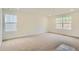 Spacious carpeted bedroom with two windows for natural light, and neutral paint at 7357 S Yank Ct, Littleton, CO 80127