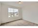 Bedroom features neutral carpet, a large window providing natural light, and neutral paint at 7357 S Yank Ct, Littleton, CO 80127