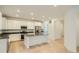 Bright kitchen with white cabinets, stainless steel appliances, center island, and hardwood floors at 7357 S Yank Ct, Littleton, CO 80127