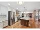 Open kitchen showcasing a large island, stainless steel appliances, and hardwood floors at 2609 S Quebec S St # 20, Denver, CO 80231