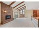 Vaulted living room featuring a brick fireplace, exposed wood beams, and sliding doors to the outside at 2609 S Quebec S St # 20, Denver, CO 80231