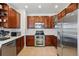 Cherry wood cabinetry, stainless steel appliances, and white subway tile backsplash accent this kitchen at 11307 Navajo Cir # A, Westminster, CO 80234