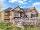 Beautiful home featuring a stylish entryway, rock landscaping, and a neutral stucco exterior at 1236 Castlecombe Ln, Monument, CO 80132
