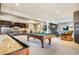 Spacious game room with pool table, shuffleboard, wet bar, and comfortable seating area at 1236 Castlecombe Ln, Monument, CO 80132