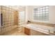 Spa-like main bathroom with glass block shower, soaking tub and decorative window at 1236 Castlecombe Ln, Monument, CO 80132