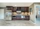 Basement wet bar featuring custom cabinets, stone backsplash, and stainless steel appliances at 1236 Castlecombe Ln, Monument, CO 80132