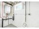 Basement utility room featuring updated appliances, exposed piping, and a window for ventilation at 3600 N Race St, Denver, CO 80205
