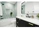 Bright bathroom with a sleek black vanity, gold hardware, and a shower with unique, vertical teal tile and a shower niche at 3600 N Race St, Denver, CO 80205