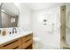 Modern bathroom features a wood vanity with matte black hardware, a large mirror, and tile flooring at 3600 N Race St, Denver, CO 80205