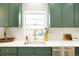 Well-lit kitchen with green cabinets, white countertops, and stainless steel appliances at 3600 N Race St, Denver, CO 80205