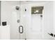 Modern bathroom shower with glass door and white tiled walls, black fixtures and opening to basement at 3600 N Race St, Denver, CO 80205