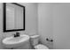 Small powder room featuring a pedestal sink, and a toilet with modern hardware and fixtures at 1415 Great Western Dr, Longmont, CO 80501