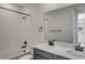 Bright bathroom featuring a shower over tub and double vanity with modern black fixtures at 1415 Great Western Dr, Longmont, CO 80501